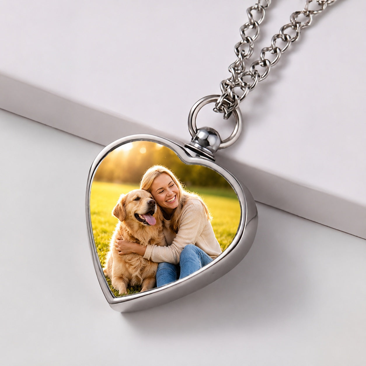 Heart-shaped photo locket with a woman and dog on a white surface