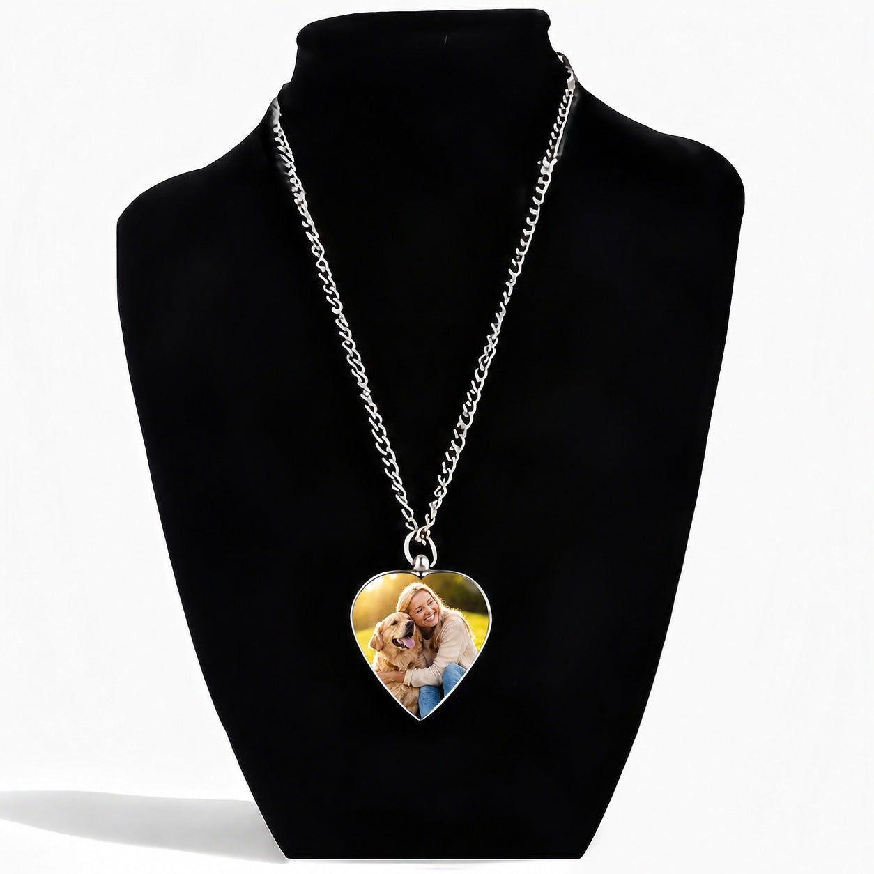 Heart-shaped photo pendant on a silver chain displayed on a black bust